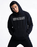 Junger Mann präsentiert den schwarzen INTOLERANT Classic Hoodie in souveräner Pose – klassisch-modernes Design für einen starken Auftritt.