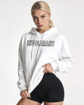 Junges Model im weißen INTOLERANT Classic Hoodie vor hellem Hintergrund – aufrechte Haltung und klarer Stil.