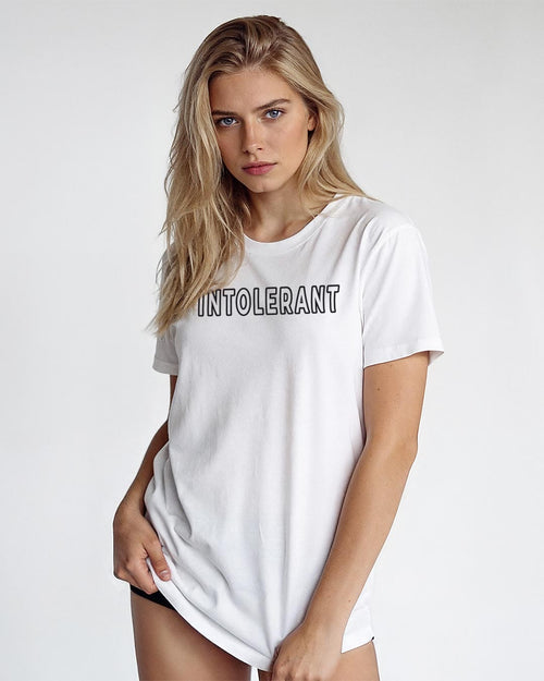 Junges Model präsentiert das weiße INTOLERANT Classic T-Shirt in lässiger Pose – sauberer und eleganter Look.