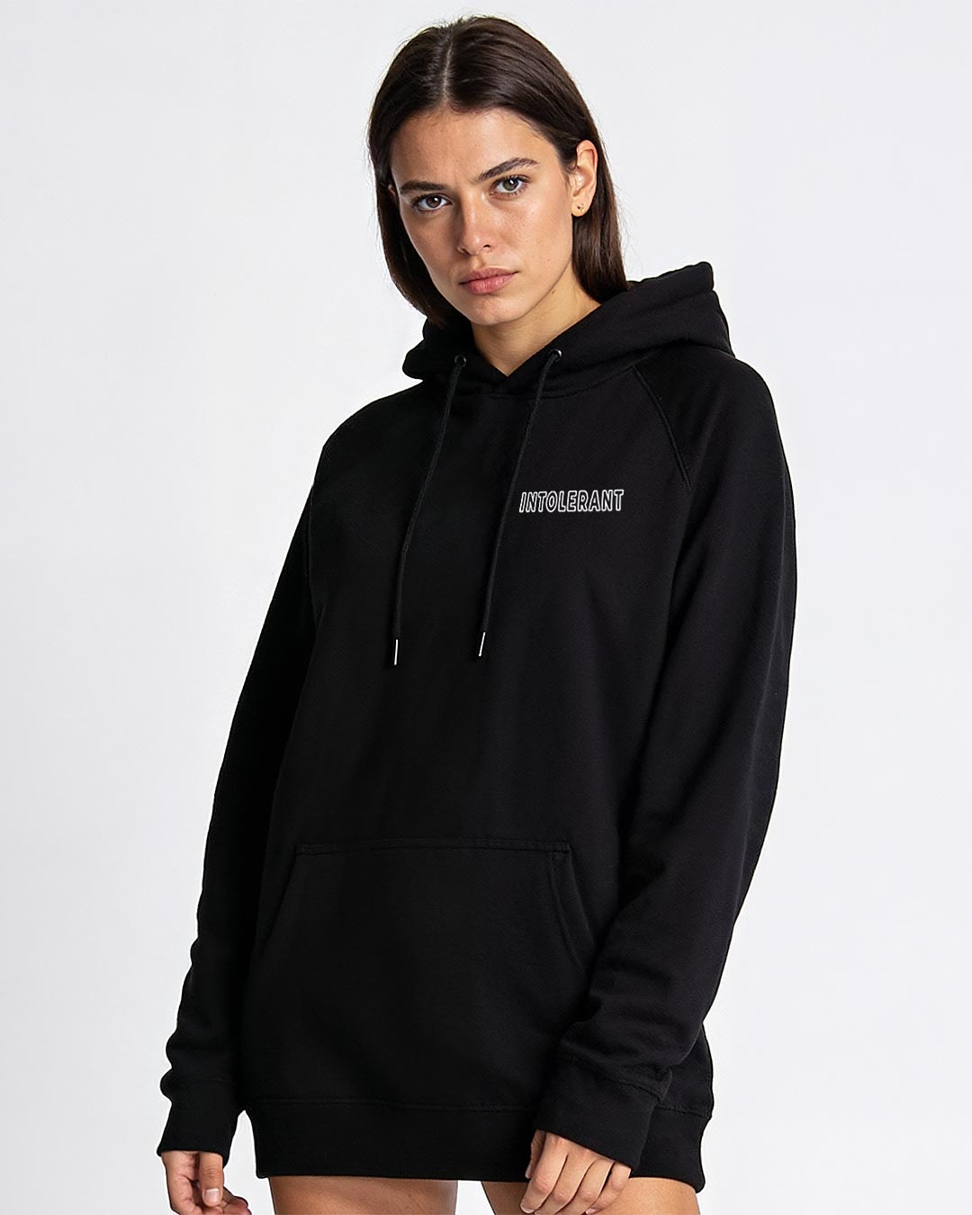 Junges hübsches Model im schwarzen INTOLERANT Minimal Hoodie – elegante Souveränität durch klare und saubere Strukturen.