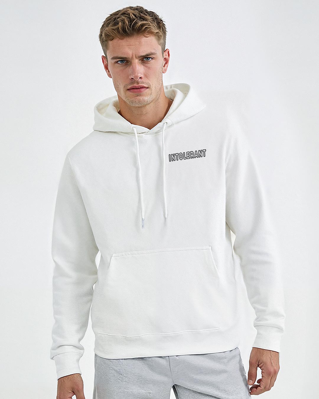 Junger Mann im weißen INTOLERANT Minimal Hoodie – souveräner Auftritt durch hochwertigen Stick und schweren Stoff.