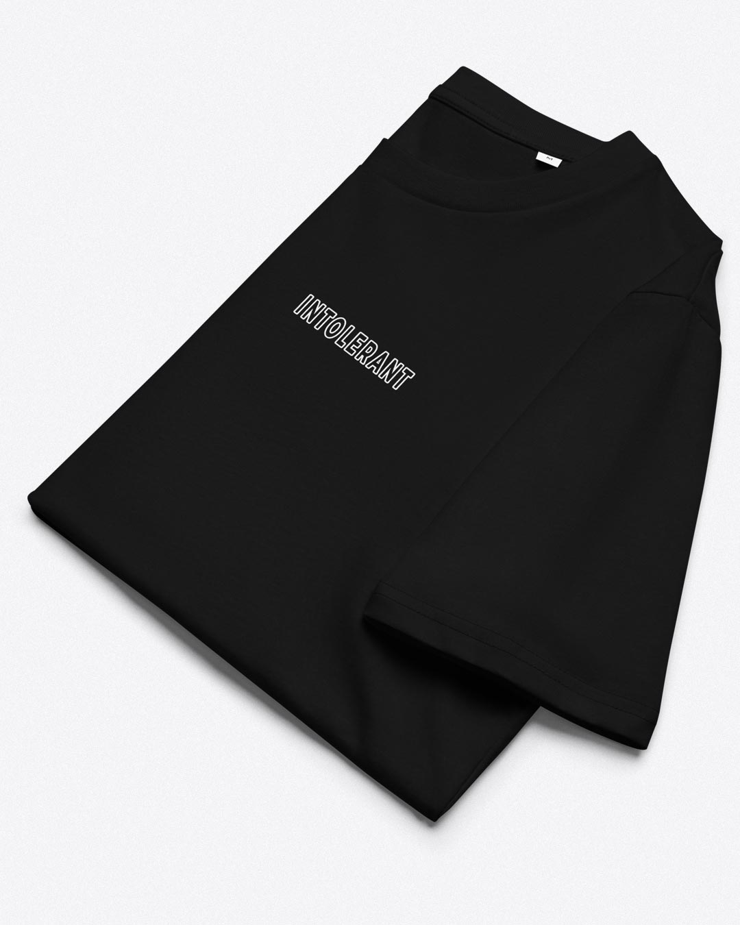 Gesamtaufnahme des gefalteten schwarzen INTOLERANT T-Shirts – präzise Linienführung auf schwarzem Stoff für einen denkwürdigen Auftritt.
