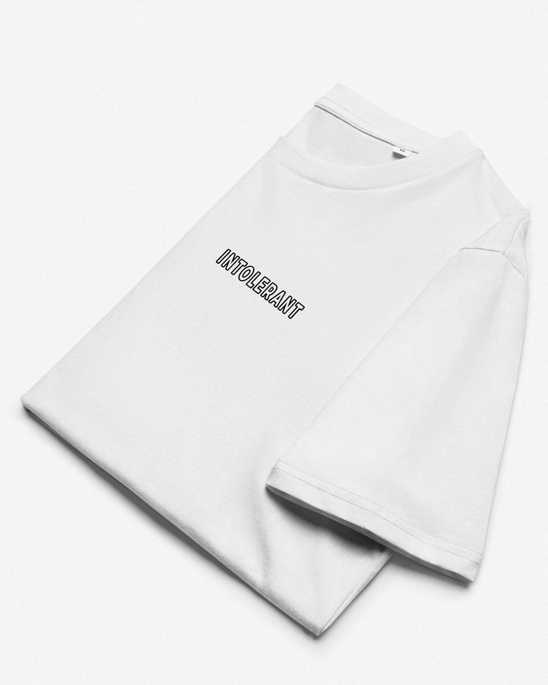 Nahaufnahme des minimalistischen INTOLERANT Drucks. Präzise Linienführung auf weißem Stoff – für einen sauberen und gelungenen Auftritt.