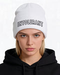 Junges Model mit der weißen INTOLERANT Statement Beanie – winterlicher Look mit Fokus auf dem hochwertigen Front-Stick.