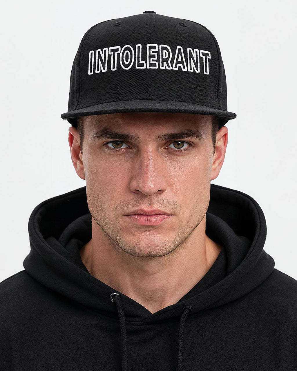 Elegannter Mann trägt die schwarze INTOLERANT Essential Snapback Cap – klarer und sportlicher Look mit markantem weißem Stick.