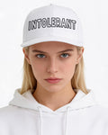 Junges Model trägt die weiße INTOLERANT Essential Snapback – klarer, sportlich-konservativer Look mit markantem Stick.